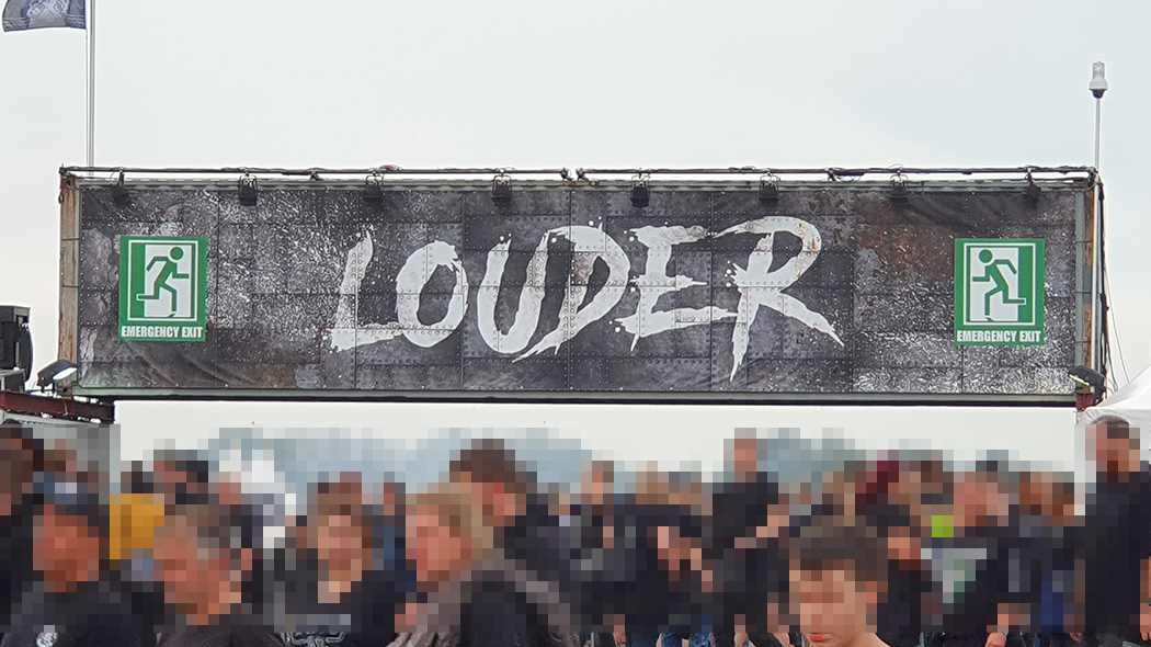 Linker Eingang auf das Festival Gelaende mit dem Banner Louder